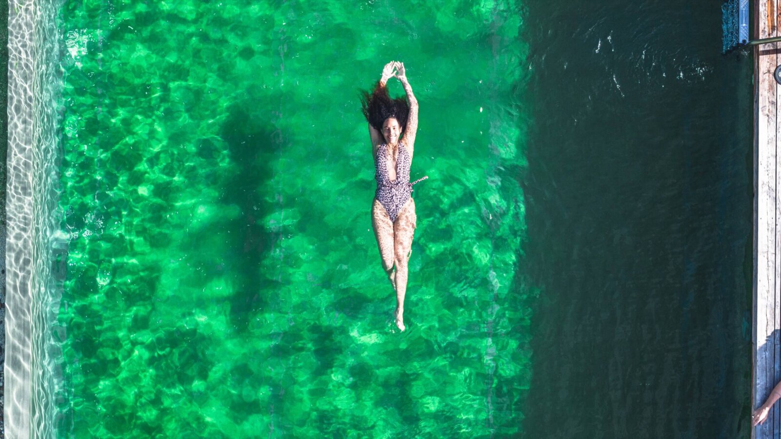 Frau schwimmt im chlorfreien Naturschwimmteich im Hotel Falkenstein