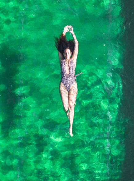 Frau schwimmt im chlorfreien Naturschwimmteich im Hotel Falkenstein