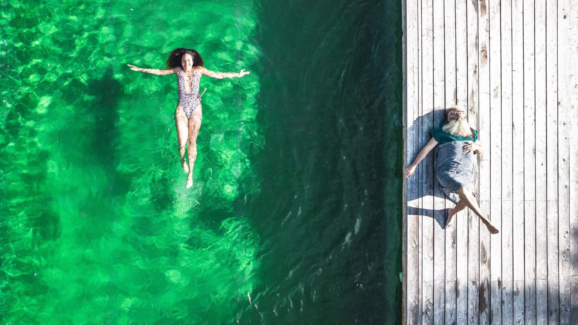Frau schwimmt im Naturbadeteich