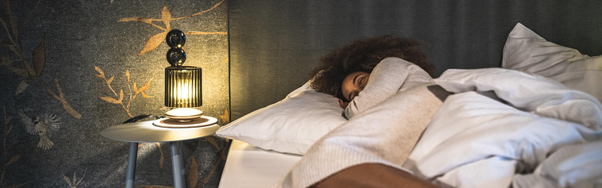 Frau liegt gemütlich im Bett im Premium Studio Vogelfrei im Hotel Falkenstein Kaprun