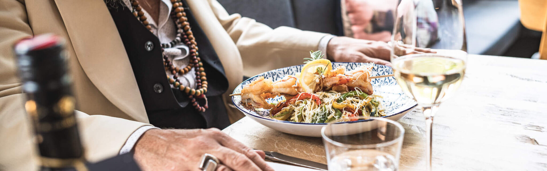Mann isst Garnelenspieß im Restaurant Federspiel
