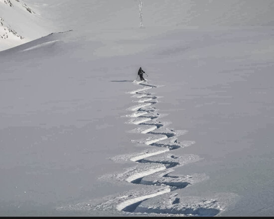 Skifahrer auf Piste mit Wedelspur