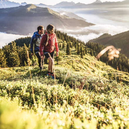 Ein Paar wandert in Zell am See. Im Hintergrund eine wunderschöne Bergkulisse